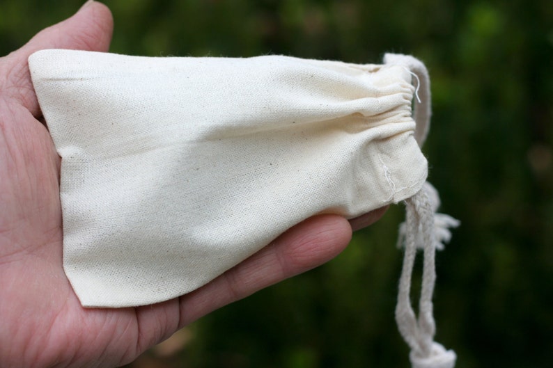 May include: A small, white cotton drawstring bag with a white cord.