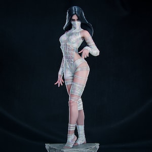 May include: A white, masked figure with long black hair stands on a stone pedestal. The figure is wearing a white, form-fitting outfit with a criss-cross pattern. The figure is posed with one hand on her hip and the other extended forward.