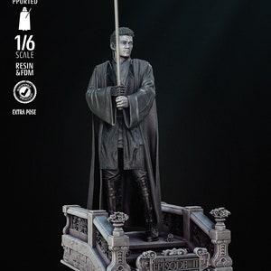 May include: A 1/6 scale resin and FDM printed figure of a Star Wars character holding a lightsaber. The figure is standing on a platform with the text "Star Wars Episode II Attack of the Clones" printed on it. The figure is gray and the platform is gray with black accents.