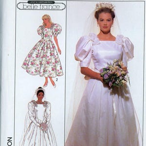 May include: Simplicity sewing pattern 9051, size 12, featuring illustrations and a photograph of a wedding dress with puff sleeves, a square neckline, and floral accents. The pattern includes options for a floral print or solid white fabric.