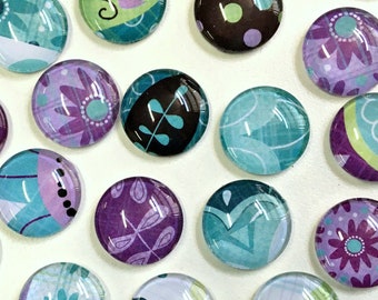 Può includere: Assortimento di magneti rotondi in vetro con vari disegni astratti in tonalità di viola, turchese e verde. I magneti presentano motivi floreali, geometrici e a foglia.