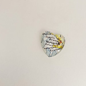 Puede incluir: Un pisapapeles de vidrio en forma de coraz&oacute;n con un mapa de Islandia. El mapa muestra las ciudades de Olafsvik, Faxafloi, Akranes, Reykjavik, Keflavik, Hafnarfjordur y Eyrarbakki.