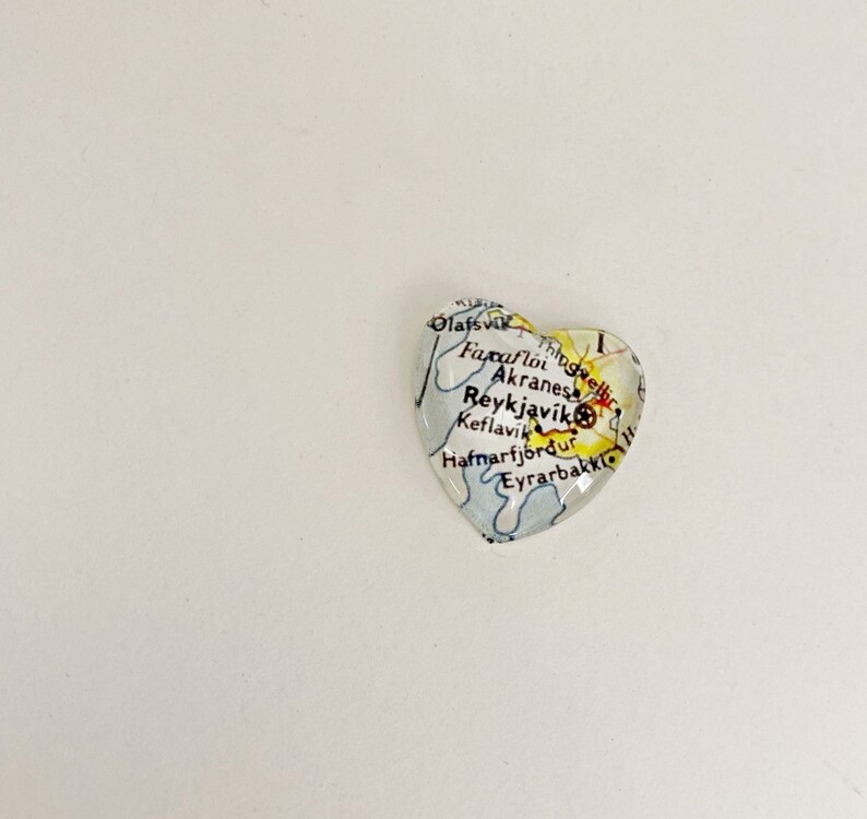 Puede incluir: Un pisapapeles de vidrio en forma de coraz&oacute;n con un mapa de Islandia. El mapa muestra las ciudades de Olafsvik, Faxafloi, Akranes, Reykjavik, Keflavik, Hafnarfjordur y Eyrarbakki.