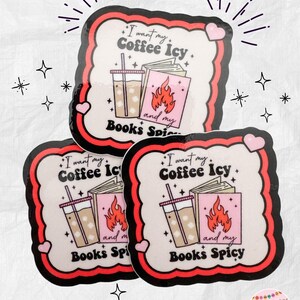 May include: Three stickers with a white background, black and red border, and pink hearts. Each sticker features a graphic of iced coffee, a book with flames, and the text "I want my Coffee Icy and my Books Spicy."