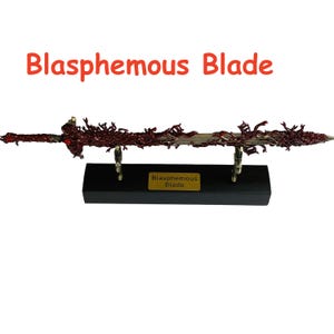 Op de afbeelding: Een decoratief zwaard met een donkerrood en zilverkleurig lemmet, gemonteerd op een zwarte basis. De tekst "Blasphemous Blade" wordt in het rood boven het zwaard weergegeven.