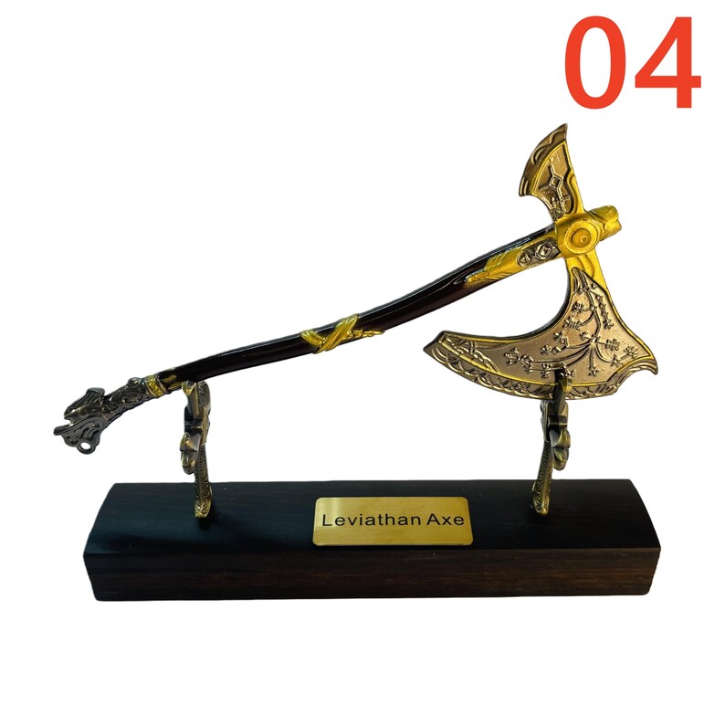 May include: A decorative Leviathan Axe replica, featuring a gold-colored blade and accents, a dark brown handle, and a black wooden base. The axe is displayed on a stand with the number "04" in the upper right corner.