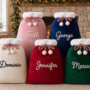 Pode incluir: Cinco sacos de presente de Natal de veludo com acabamento em pele sintética branca e cordões trançados em vermelho e branco com pompons. Os sacos são rosa, azul-marinho, creme, vermelho e verde-escuro, personalizados com nomes em cursivo.
