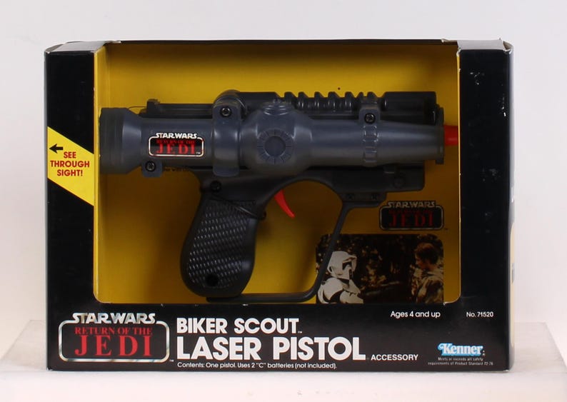 May include: A Star Wars Biker Scout Laser Pistol toy in its original packaging. The black and gray pistol has a red trigger and is packaged in a black box with yellow interior. The box features the text "Star Wars Return of the Jedi".