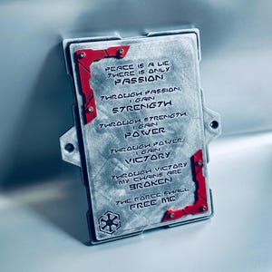 May include: A rectangular, metallic plaque with red corner accents and the text "Peace is a lie, there is only passion." The plaque also features the Star Wars logo and additional text.