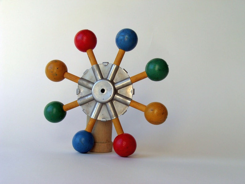 vintage wood and metal game or toy component with brighly painted balls which could easily be made to spin for hours of fun
