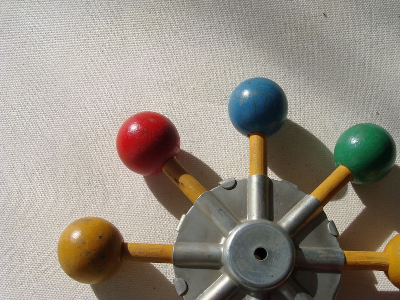 vintage wood and metal game or toy component with brighly painted balls which could easily be made to spin for hours of fun