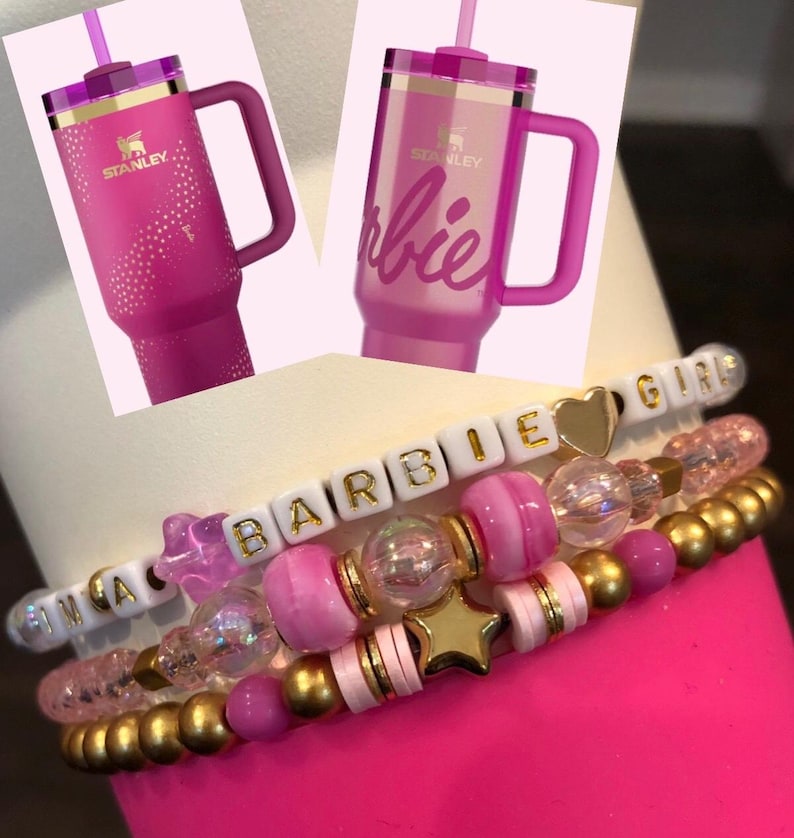 Pu&ograve; includere: Due bicchieri in acciaio inossidabile rosa con dettagli dorati e una cannuccia. Un bicchiere ha la scritta "Barbie" e l'altro la scritta "Stanley". Un braccialetto rosa e oro con la scritta "Barbie Girl".