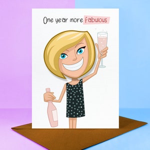 May include: A greeting card featuring a cartoon illustration of a woman in a black dress holding a glass of pink champagne. The text on the card reads "One year more fabulous".