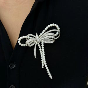 Broszka z lśniącej srebrnej perły w kształcie kokardy: naturalna biała perła, biżuteria ślubna