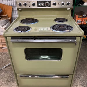 Cocina eléctrica GE vintage de los años 70, color verde aguacate, estilo retro de mediados de siglo.