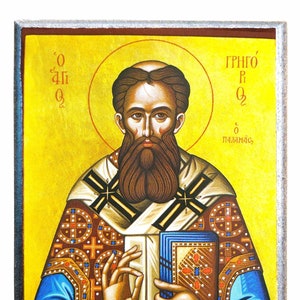Op de afbeelding: Een Byzantijnse icoon van Sint Gregorius Palamas, een Grieks-orthodoxe theoloog. De icoon toont hem in een traditionele bisschopskleed met een gouden kruis en een boek in zijn hand. De achtergrond is heldergeel met een halo rond zijn hoofd. De tekst op de icoon luidt "O Gregorius Palamas".