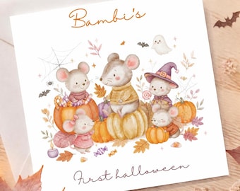 Op de afbeelding: Een vierkante wenskaart met een aquarelillustratie van vijf muizen omringd door pompoenen en herfstbladeren. De tekst Bambi's First halloween is in bruin handschrift gedrukt. De kaart ligt bovenop een witte envelop.