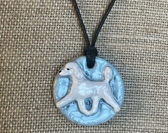Poodle (white) jewelry pendant in clay.  Baby blue backround. Adjustable black cord necklace