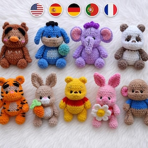Puede incluir: Una colección de nueve pequeños peluches de ganchillo hechos a mano con varios personajes animales, incluyendo un oso marrón, un burro azul, un elefante morado, un panda, un tigre, un conejo con una zanahoria, un oso amarillo, un cerdito rosa y un mono.