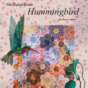 May include: A quilt pattern featuring a hummingbird with a colorful background of hexagons and flowers. The quilt is titled "Old English Garden Hummingbird" by Darcy Ashton. The quilt size is 37 inches by 42 inches and the hexie size is 1-1/4 inches.