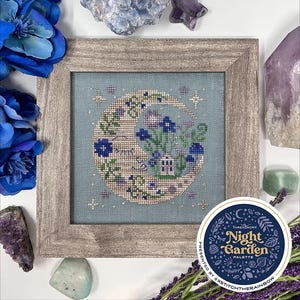 May include: A cross stitch pattern featuring a crescent moon with a garden scene inside. The moon is surrounded by stars and the text "Night Garden Palette" is on a circle with a floral design.