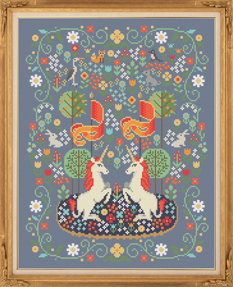 May include: A cross-stitch pattern featuring two white unicorns with gold horns and manes, facing each other in a whimsical forest scene. The background is a blue-grey color with a variety of colorful flowers, trees, and birds.