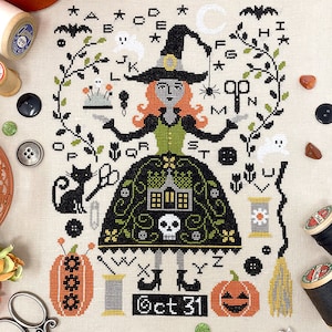 May include: A cross-stitch pattern featuring a witch with a black hat and green dress, holding a pair of scissors and a pincushion. The design includes a black cat, a house, a pumpkin, a broom, and the letters of the alphabet. The text "Oct 31" is also included.