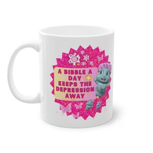 Könnte beinhalten: Weiße Keramiktasse mit einem pinkfarbenen und glitzernden Design mit einer Comicfigur und dem Text "A Bibble a Day Keeps the Depression Away".