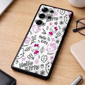 May include: A black phone case featuring a white background with a repeating pattern of Hello Kitty characters, flowers, and leaves in black and pink. The text "Hello Kitty" is also displayed.