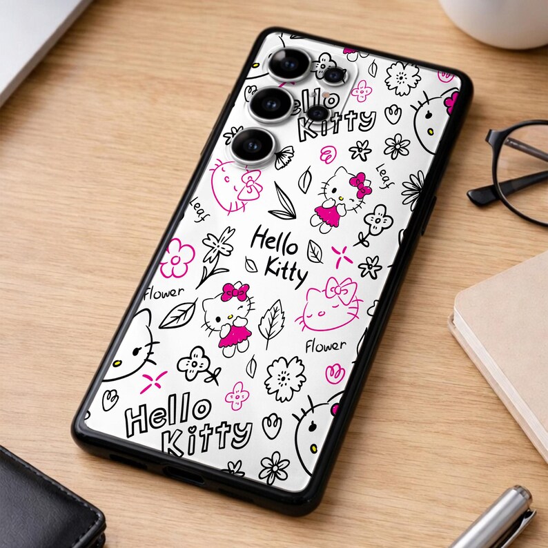 May include: A black phone case featuring a white background with a repeating pattern of Hello Kitty characters, flowers, and leaves in black and pink. The text "Hello Kitty" is also displayed.
