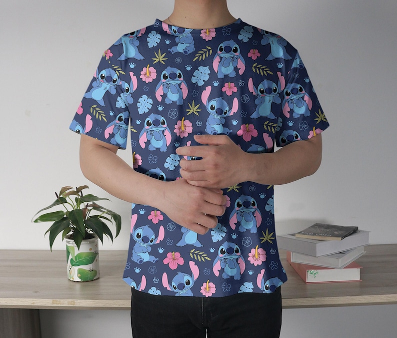 Pu&ograve; includere: Una maglietta blu navy a maniche corte con un motivo ripetuto del personaggio Stitch del film Lilo & Stitch. Il design include Stitch, fiori rosa e fogliame verde. La maglietta &egrave; realizzata in materiale morbido.