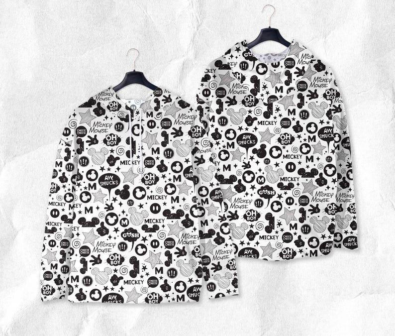 Peut inclure: Deux chemises &agrave; manches longues avec un motif Mickey Mouse noir et blanc. Le motif comprend des visages de Mickey Mouse, des &eacute;toiles, des bulles et les phrases "Mickey Mouse", "Oh Boy" et "Aw Shucks".