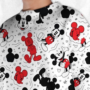 May include: White sweatshirt with a repeating pattern of Mickey Mouse in various poses, black Mickey Mouse silhouettes, red shorts, hearts, stars, and other small shapes. The sweatshirt has a crew neck.