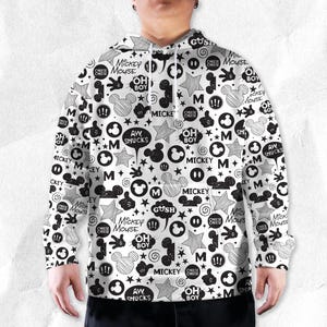 Peut inclure: Sweat &agrave; capuche blanc avec un motif noir et blanc de Mickey Mouse. Le design comprend des silhouettes de Mickey Mouse, des &eacute;toiles, des bulles et du texte tel que "Mickey Mouse", "Oh Boy" et "Aw Shucks".