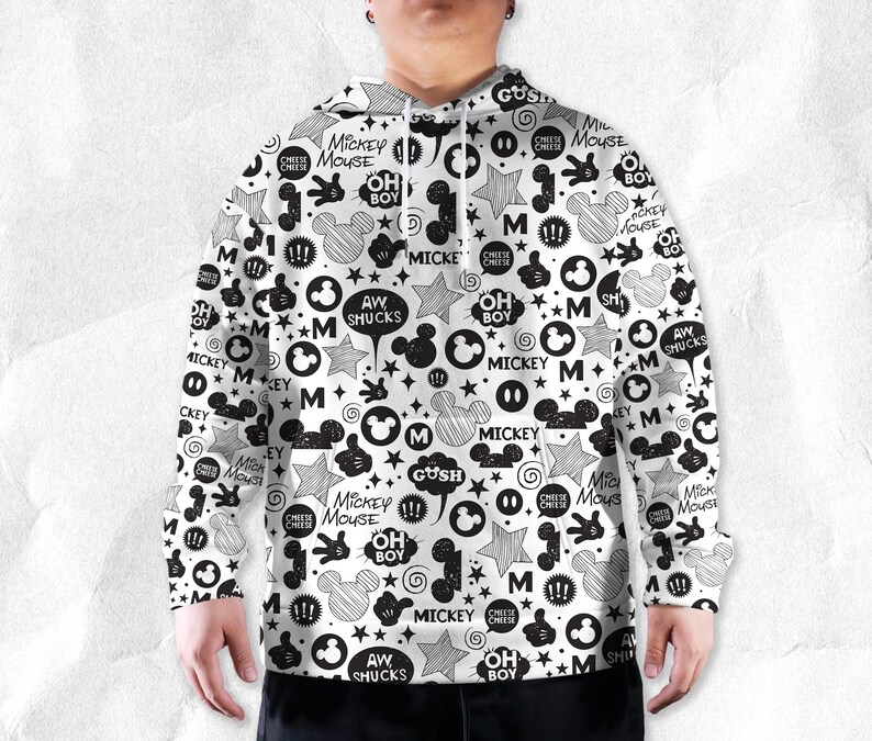 Peut inclure: Sweat &agrave; capuche blanc avec un motif noir et blanc de Mickey Mouse. Le design comprend des silhouettes de Mickey Mouse, des &eacute;toiles, des bulles et du texte tel que "Mickey Mouse", "Oh Boy" et "Aw Shucks".