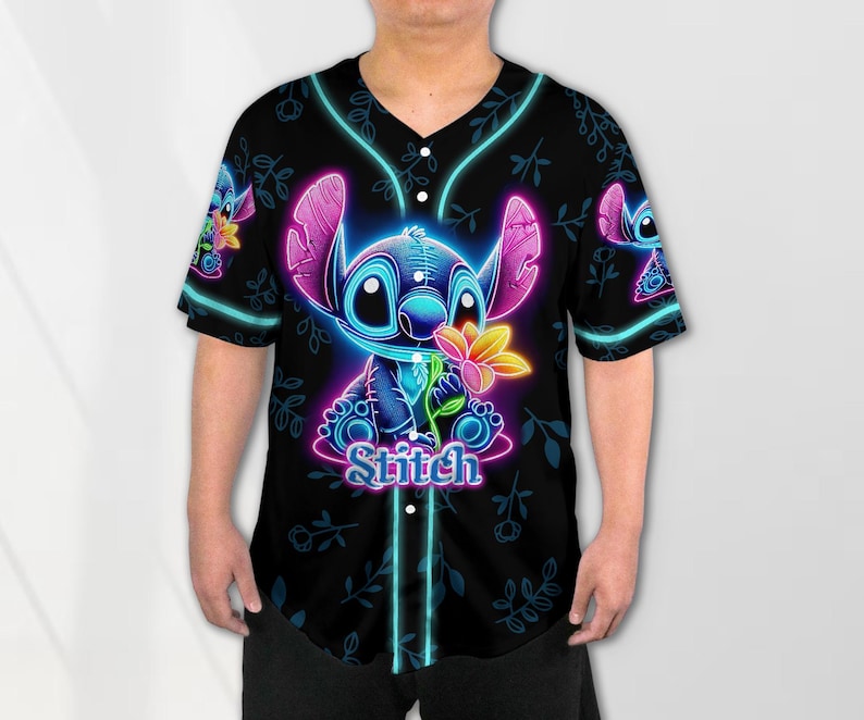 Puede incluir: Una camiseta de b&eacute;isbol negra con un personaje Stitch azul ne&oacute;n y rosa sosteniendo una flor. El texto "Stitch" est&aacute; impreso debajo del personaje.