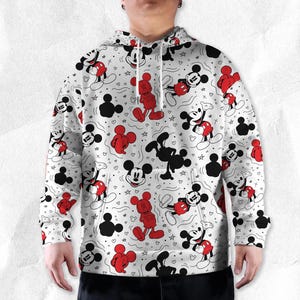 May include: White hoodie with a repeating pattern of Mickey Mouse in red, black, and white. The design includes various poses of Mickey, along with stars and hearts. The hoodie has a drawstring hood and a kangaroo pocket.
