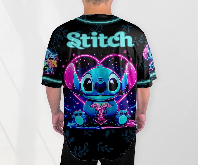 Puede incluir: Una camiseta negra con un gr&aacute;fico de Stitch de Lilo & Stitch en azul ne&oacute;n y rosa sosteniendo un coraz&oacute;n. El texto "Stitch" est&aacute; escrito en una fuente azul ne&oacute;n en la parte superior del gr&aacute;fico.
