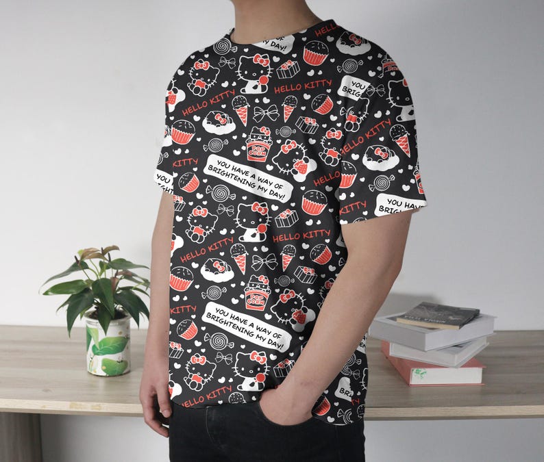 May include: Black t-shirt featuring a repeating pattern of Hello Kitty characters, cupcakes, ice cream cones, and candies in red and white. The shirt includes the text "Hello Kitty" and "You have a way of brightening my day!"