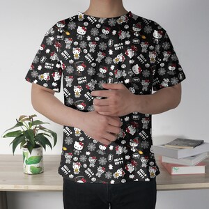 May include: Black t-shirt featuring a repeating pattern of Hello Kitty characters in various Halloween-themed costumes. The design includes spiderwebs, bats, and the words "Hello Kitty" in white. The shirt has short sleeves and a crew neck.