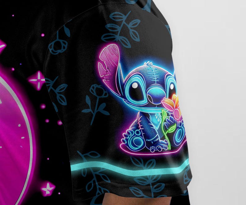 Puede incluir: Una camiseta negra con un personaje Stitch azul ne&oacute;n sosteniendo una flor. El fondo presenta un patr&oacute;n floral y un c&iacute;rculo rosa con estrellas blancas.
