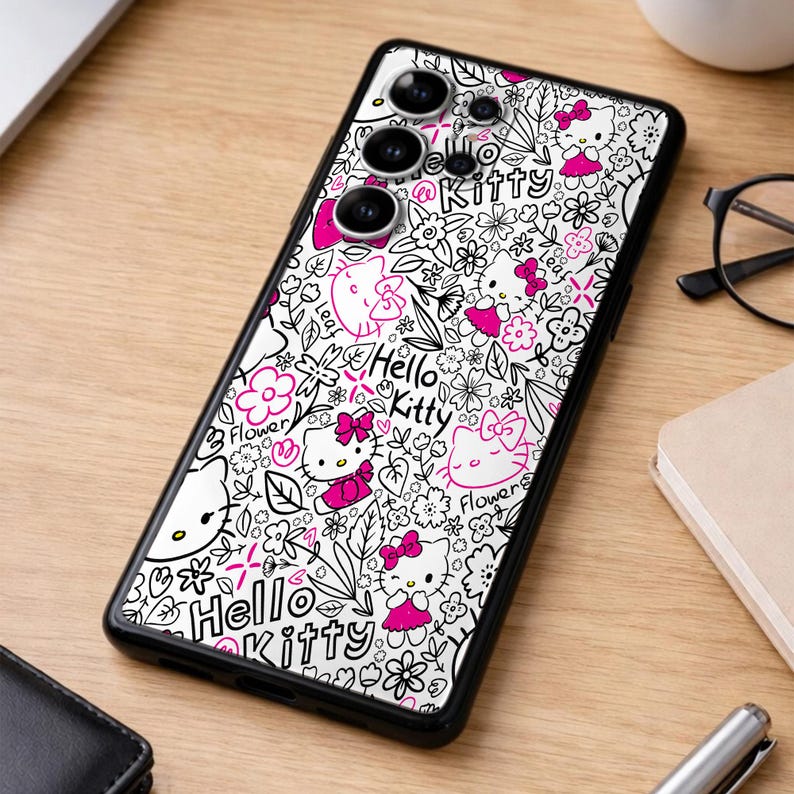 May include: Black phone case featuring a white background with a repeating pattern of Hello Kitty characters, flowers, and leaves in black and pink. The phone case has a black border and a camera cutout.