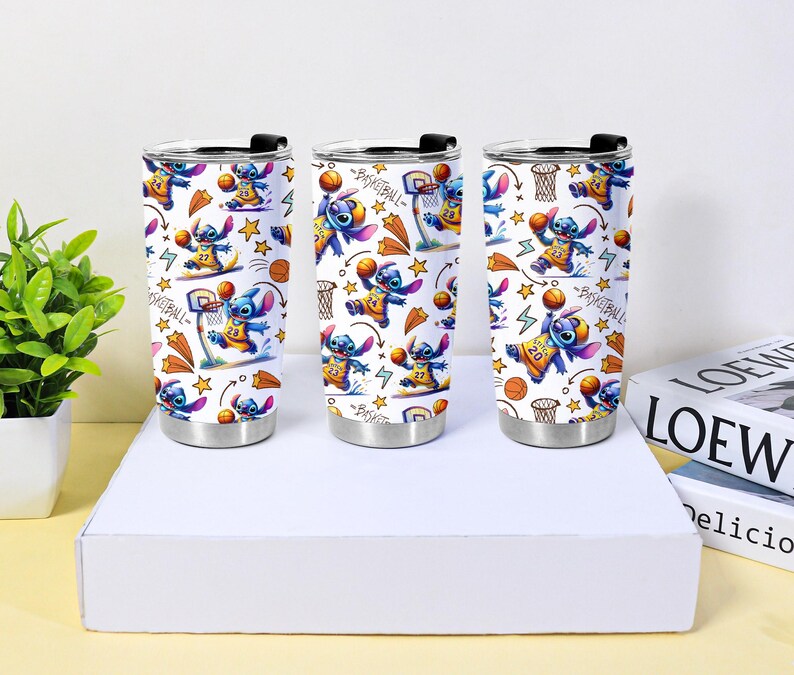 May include: Three stainless steel tumblers with a basketball-themed design featuring the character Stitch. The design includes Stitch playing basketball, basketball hoops, stars, and lightning bolts on a white background. Each tumbler has a black lid.