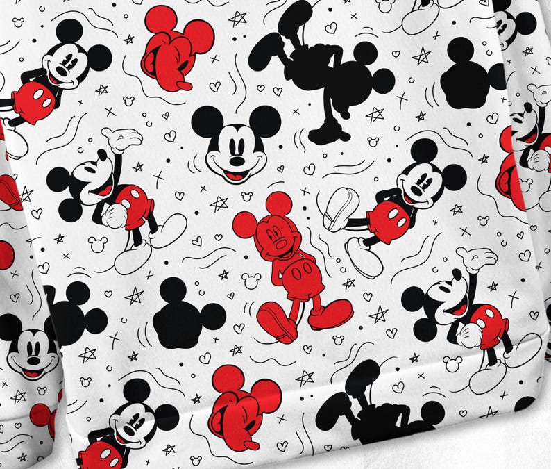 May include: White fabric featuring a repeating pattern of Mickey Mouse in various poses. Mickey is shown in red shorts, black shoes, and a smiling face. The background includes hearts, stars, and other doodles. The design is suitable for clothing.