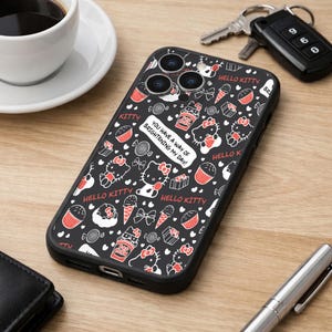 May include: Black phone case featuring a Hello Kitty design with red and white accents. The case includes images of cupcakes, ice cream cones, and the text "You have a way of brightening my day!"