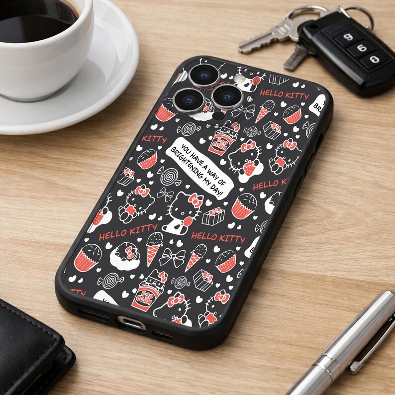 May include: Black phone case featuring a Hello Kitty design with red and white accents. The case includes images of cupcakes, ice cream cones, and the text "You have a way of brightening my day!"