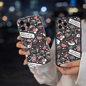 May include: Two black phone cases with a repeating pattern of Hello Kitty, cupcakes, ice cream, and bows in white and red. One case has the text "HAVE A WAY OF BRIGHTENING MY DAY!" and "HELLO KITTY".