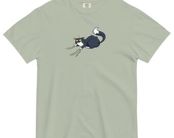 Puede incluir: Una camiseta verde claro con una ilustración de dibujos animados de un gato blanco y negro con ojos amarillos, que parece asustado y está arañando algo.