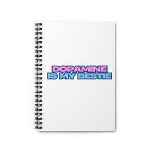 May include: A white spiral notebook with the text "DOPAMINE IS MY BESTIE" in pink and blue lettering.