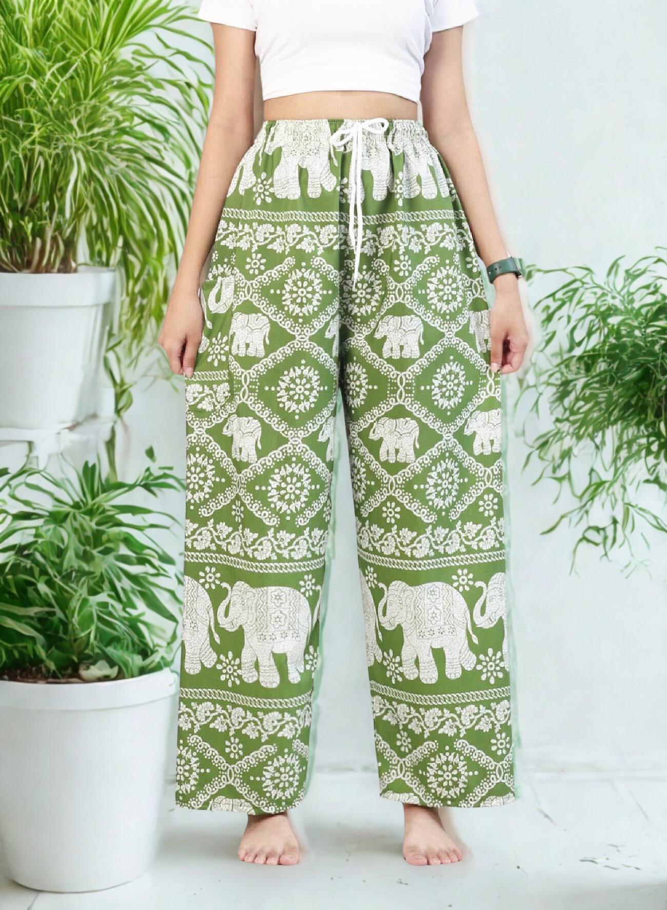 May include: Green and white elephant print pants with a drawstring waist. The pants feature a repeating pattern of elephants and floral designs. The pants are wide-legged and appear to be made of a lightweight fabric.
